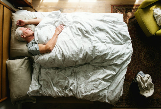 A man lying in a bed on his back