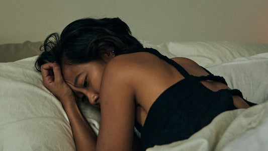 A woman lying on her stomach in a white bed