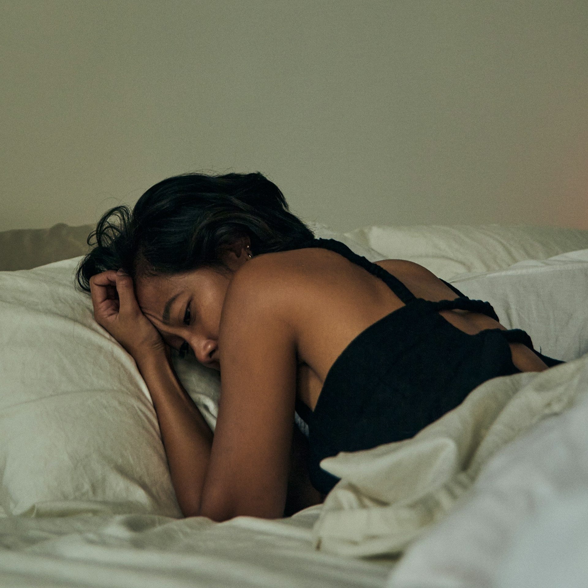 Woman sleeping on a bed with a neutral background