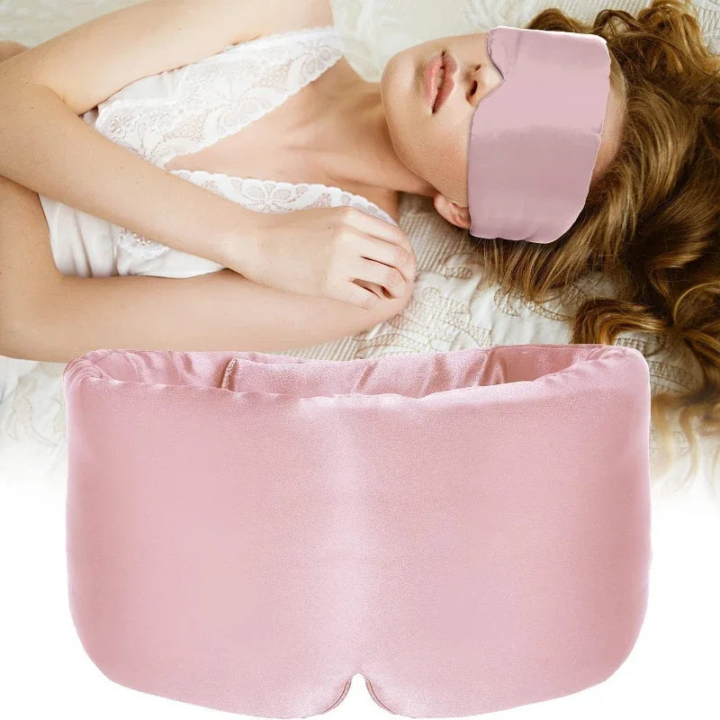 Woman wearing a pink eye mask and holding a matching pillow, lying on a white lace blanket.