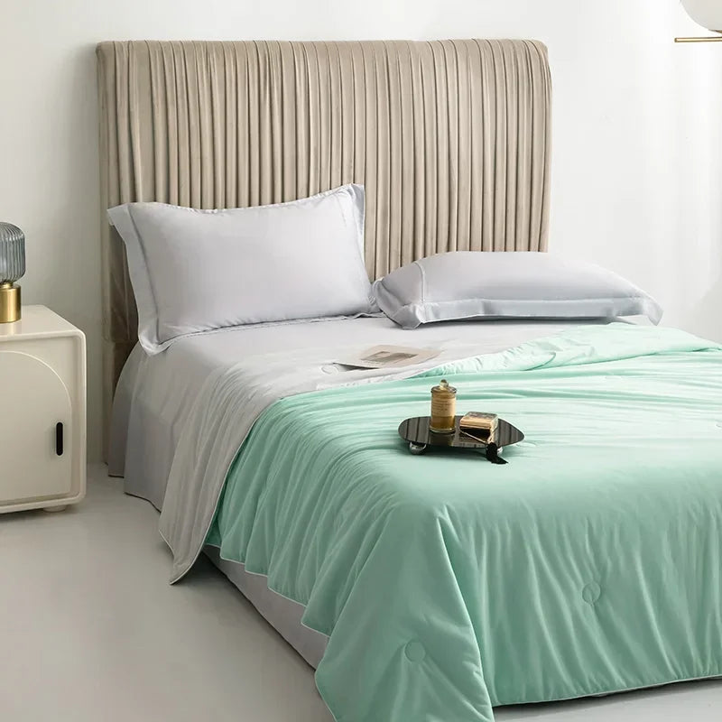 Bed with white bedding and a green throw blanket in a bedroom setting.