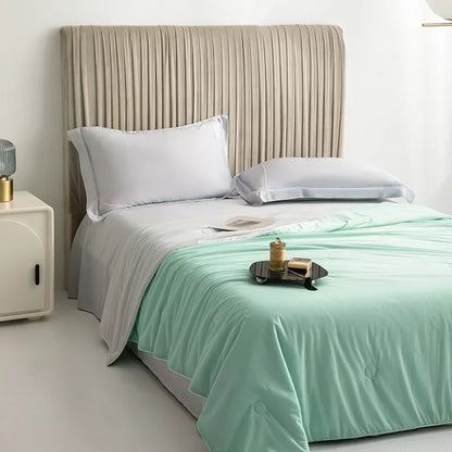 Bed with white bedding and a green throw blanket in a bedroom setting.