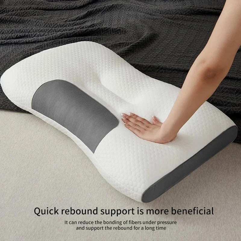Cervical pillow with a person's hand on it, placed on a bed.