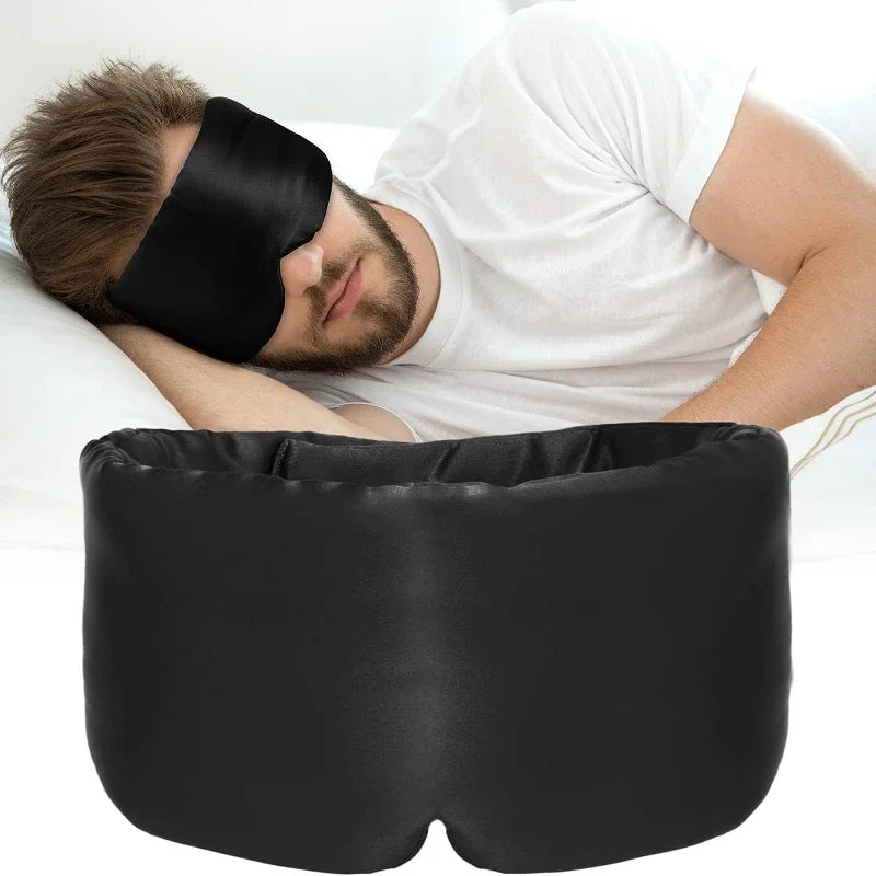 Man wearing a black sleep mask and using a black pillow on a white background