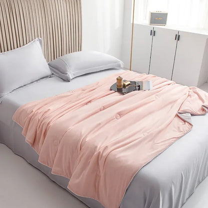 Pink blanket draped over a bed in a bedroom setting